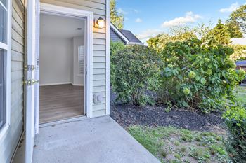 A small house with a white door and a small garden in front.